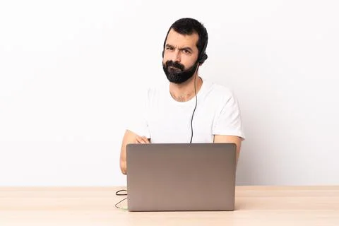 Telemarketer caucasian man working with a headset and with laptop feeling ups Foto stock