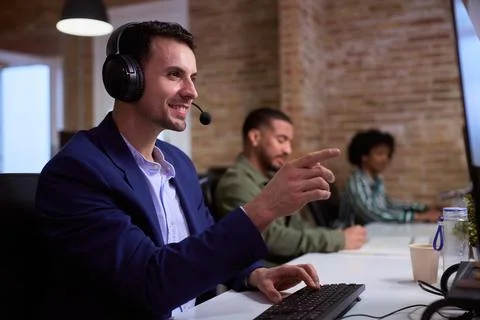 Telemarketer working with headset and pointing finger in office Stock Photos