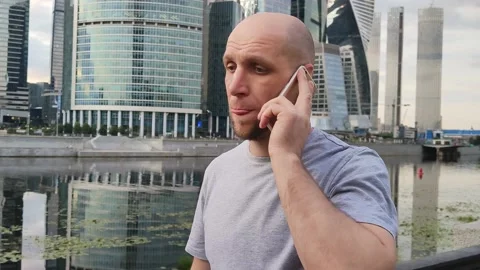 Telephone conversation against the backdrop of high-rise buildings. Stock Footage 201303331