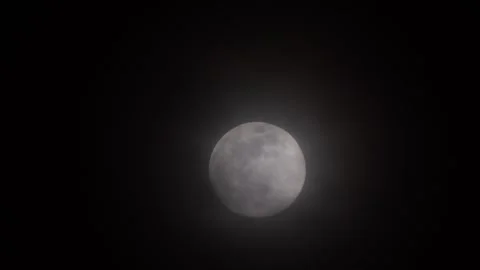 Telephoto close-up of full moon with thin clouds passing in dark night sky Video stock 341669595