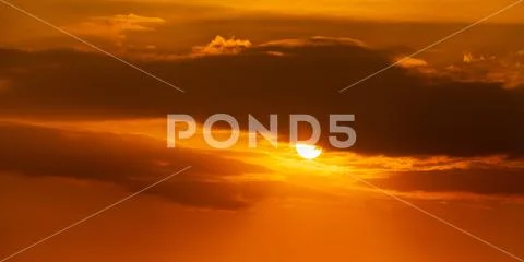 Telephoto photo of yellow orange sunset sunrise, clouds, sky golden hour Stock Photos