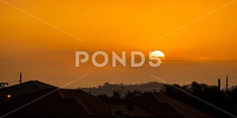 Telephoto photo of yellow orange sunset sunrise, clouds, sky golden hour Stock Photos
