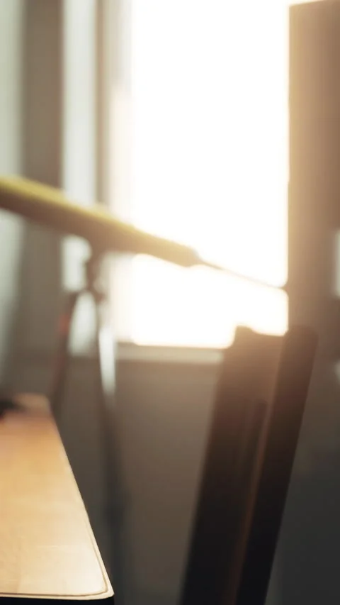 Telescope on desk looking out window at sunset in quiet room setting Stock Footage 339393101