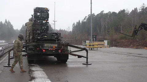 Telescopic handler approaching trailer loaded Patriot missiles Stock Footage 102707636