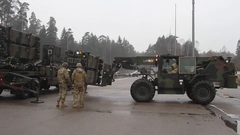 Telescopic handler lowering forks carrying Patriot missiles Stock Footage 102707786