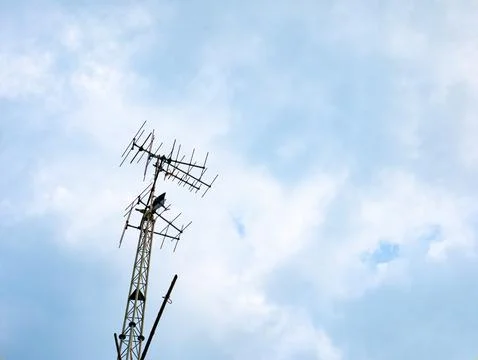 Television antenna tower with multiple directional arrays against blue clou.. Foto stock