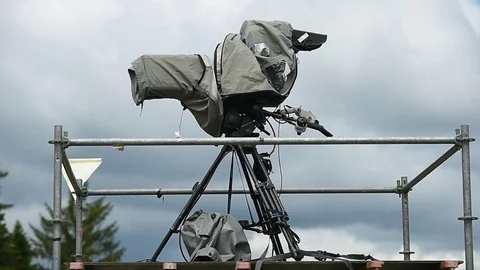 Television broadcast camera setup on a tripod and protected by a rain cover 스톡 동영상 108934551
