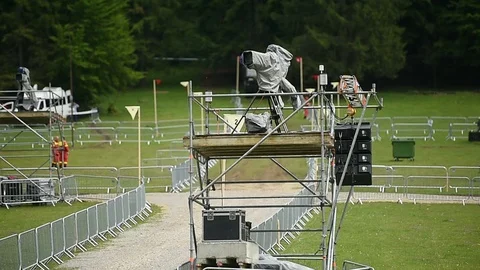 Television broadcast camera setup on a tripod and protected by a rain cover 스톡 동영상 108934553