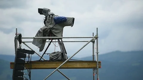 Television broadcast camera setup on a tripod and protected by a rain cover 스톡 동영상 108934619