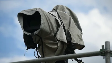 Television broadcast camera setup on a tripod and protected by a rain cover 스톡 동영상 108934676