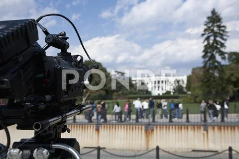 A Television Camera Filming Tourists In Front Of The White House