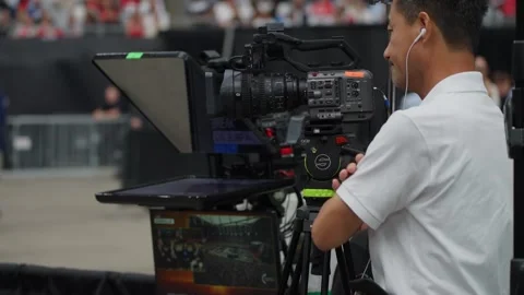 A television camera operator films the crowd at the Charlie Kirk memorial Stock Footage 345297970