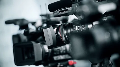 Television cameras in a row broadcasting a live media event Stock Footage