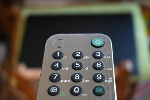 Television remote control in front of a screen Stock Photos