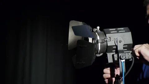 In the television studio, the worker adjusts the lighting device while preparing Stock Footage 90829238