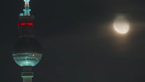 A television tower against the backdrop of a cityscape at night during the full Stock Footage 318001137