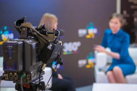 Television video camera recording interview in broadcast news studio Fotos de archivo