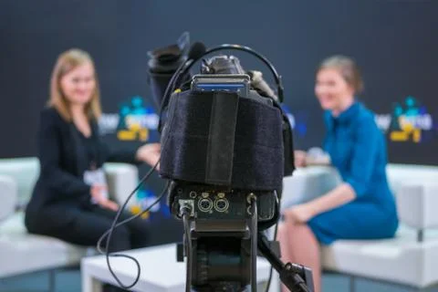 Television video camera recording interview in broadcast news studio Fotos de archivo