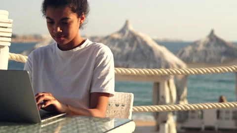 Telework. Concentrated young mixed race woman studying, working on laptop and Stock Footage 149441286