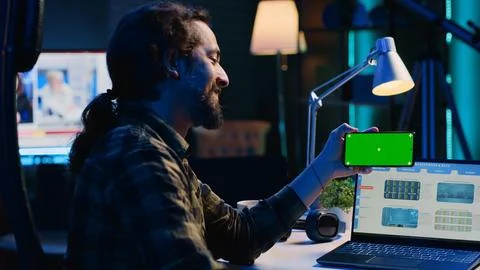 Teleworker checks statistics on laptop, crosschecking with data on mockup phone Stock Photos