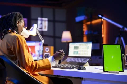 Teleworker in home office completes spreadsheets on laptop next to mockup tablet Stock Photos