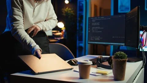 Teleworking programmer arriving in home office, starting coding Foto stock