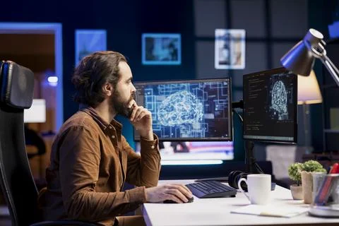 Teleworking programmer working with AI deep neural networks on desktop PC Stock Photos