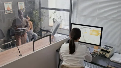 Teller Assisting Elderly Customer Holding Documents at Bank Office Stock Footage 330967916