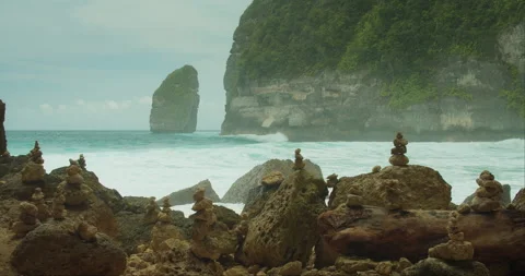 Tembeling Beach Rock Formations. The ocean waves crash against unique rocky Stock Footage 277297241