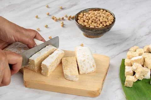 Tempe Made From Fermented Soybeans Cut by Asian Female Hand Stock Photos