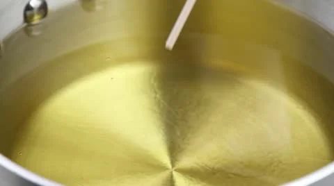 The temperature of frying fat being checked (wooden stick test) Stock-Footage 24647311
