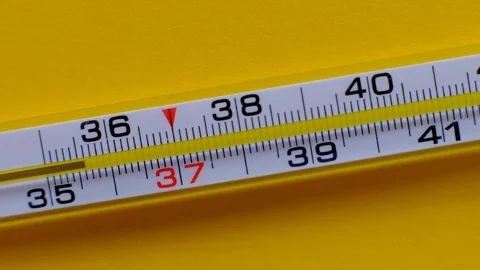 Temperature rising shown on a thermometer on a yellow background close-up. Stock Footage 119074722