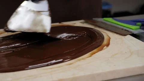 Tempering of the chocolate on the wooden surface. Stock Footage 270061767