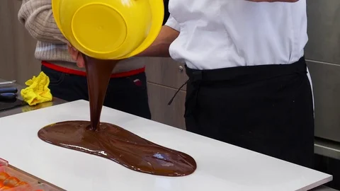 Tempering melted chocolate on table Stock Footage 128228589