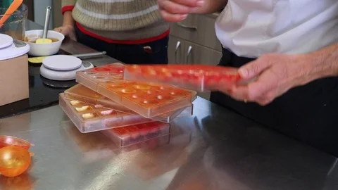 Tempering melted white chocolate for molded bonbons Stock Footage 127291265