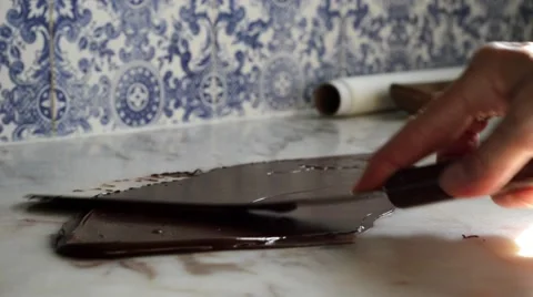 Tempering smooth dark chocolate on marble counter top surface Stock Footage 66400079