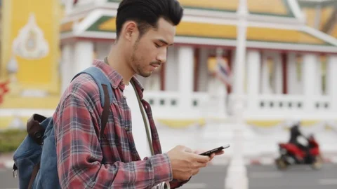 Temple, Asian  man tourist using  smart phone at Tourist attraction Roadside Stock Footage 118836751