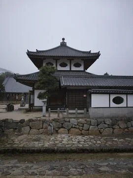 A temple hall and a distant red torii in the mist, Japan Stock Photos