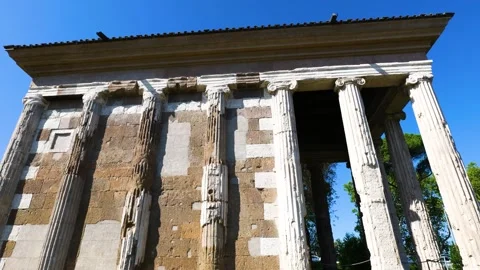 Temple portunus displays weathered ionic columns patchwork stone façade circular Stock Footage 324871972