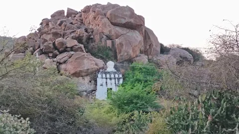 Temple structure built among large rocky hills and dense vegetation Stock Footage 327982298