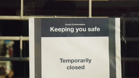 Temporary closed, keeping you safe: notice at the entrance door of a closed shop Stock Footage 146500895