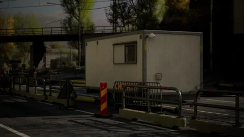 Temporary construction site office with barriers near busy road Stock Footage 304524210