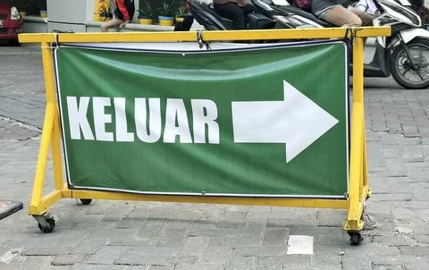 Temporary green exit banner on yellow metal barrier standing on paved groun.. Stock Photos