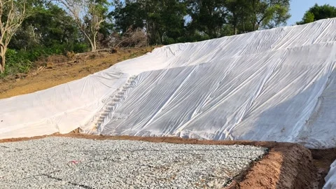 Temporary Plastic Sheeting on Cut Soil Slope for Erosion Control Stock Footage 336646834