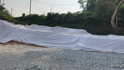 Temporary Plastic Sheeting on Cut Soil Slope for Erosion Control Stock Footage 336646852