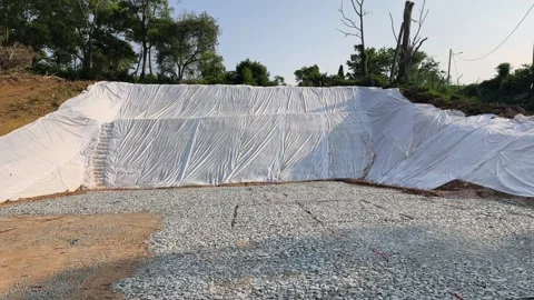 Temporary Plastic Sheeting on Cut Soil Slope for Erosion Control Stock Footage 336646858