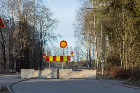 A temporary road closure barrier, featuring substantial concrete blocks and a Fotos Stock
