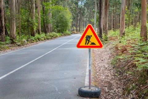 Temporary road sign indicating work on a small road in the forest Stock Photos