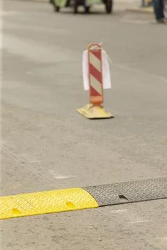 Temporary road speed bump with traffic bollard on urban street Stock Photos