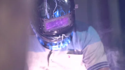 A temporary worker is doing welding wearing a shield Stock Footage 287328541